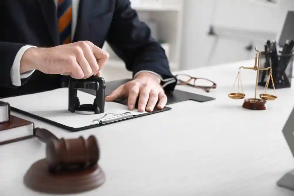 Close-up of a notary or legal professional's hands using an official stamp on documents