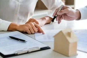 Close-up of a person's hands pointing at a real estate contract
